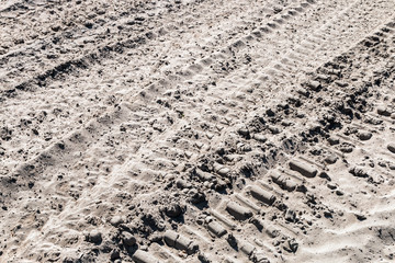 ground and sand and tracks left by tank, tractor or other vehicles