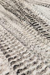 ground and sand and tracks left by tank, tractor or other vehicles