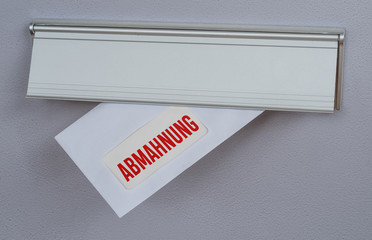  Brief mit der Beschriftung Abmahnung in Briefschlitz