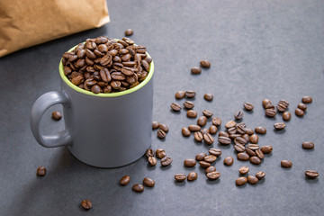coffee beans in dark coffee cup on isolated dark textured background
