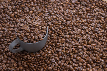 coffee beans in dark cup on mixed coffee beans background