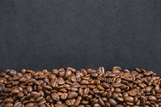 mockup of coffee beans on isolated dark textured background © mertkantekin