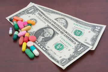 Drugs and dollars on table, cost of drugs concept