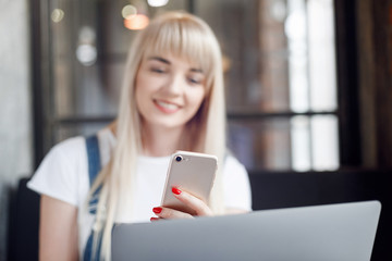 Young girl at cafe drinking coffee and using mobile phone. Online shopping