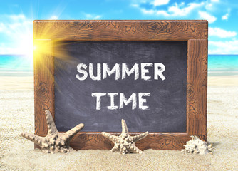 Blackboard with Summer Time text on the beach in summer 