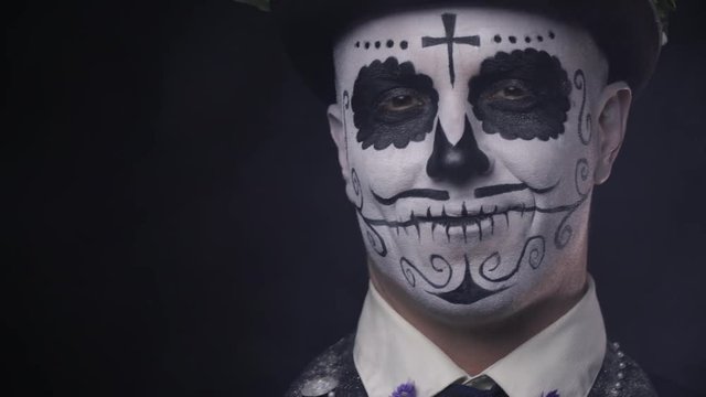 Close up shot of a man with traditional Santa Muerte face paint and a hat, 4k