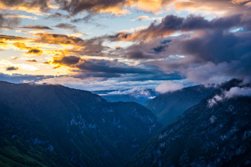 Obraz premium Montenegro, Tara river canyon nature landscape from aerial perspective decorated with colorful sunset sky and glowing clouds shining over majestic national park near zabljak