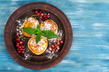 Dairy products, cottage cheese pancakes with powdered sugar and berries