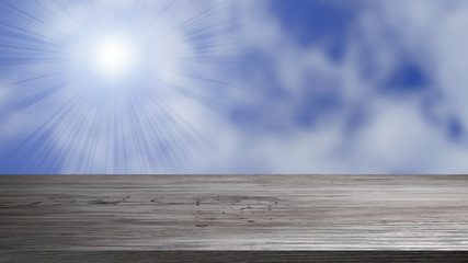 Holzplatte vor blauem Himmel mit strahlender Sonne
