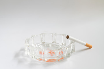 Cigarette and ashtray on white background