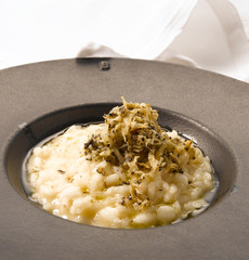 Alubias blancas con trufa sobre plato de porcelana negra