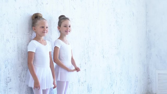 Children from ballet school run in embraces of the teacher of the ballerina. Little girls of the ballerina run to embrace the teacher. Beautiful view.