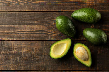 Fresh ripe tasty avocado on a brown wooden background. tropical fruit top view. space for text