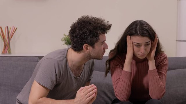 sad, betrayed young woman not want to forgive her repentant husband- indoor