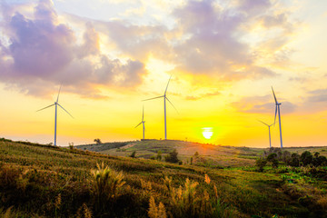 Night scene of landscape mountain view with windmills on the hill with sunset sky, Wind turbine generator to build electricity power in rural area, Electricity power concept