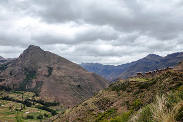 Landscape with green Andean Mountains and Inca ruins on the hiking path in Pisac archeological park, Peru