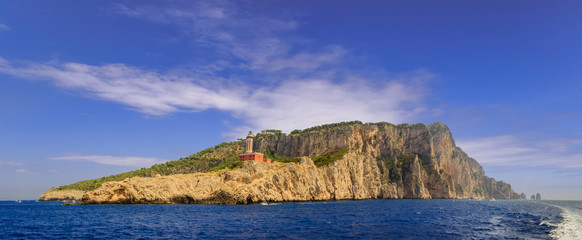 Landscapes of the  Capri Island from the sea. View of the coastline with the rocky shores and Punta Carena Lighthouse.