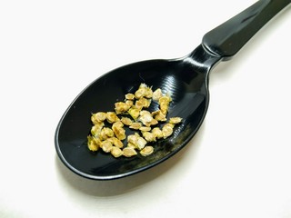 A picture of tomato seed's on a black spoon