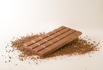 Chocolate bar on cocoa powder isolated on white background.