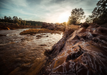 Sunset in the river with rocks