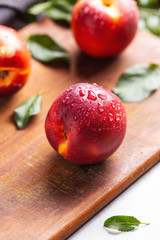 Nectarines and leaves on wood table