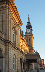 a side view of the facade and clock tower of the historic victorian atkinson building in southport merseyside against a blue summer sky