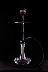 Obraz na płótnie Canvas A hookah in the glass extended flask with water and a carved bowl from a tree