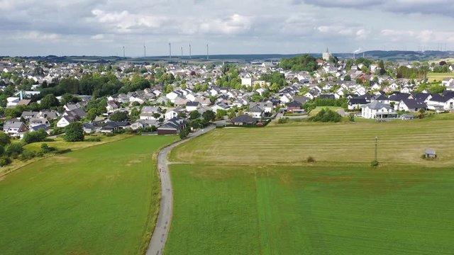 Flight over city Brilon, North Rhine Westphalia, Germany from direction Derkerborn. Western view shows the center of the city. Surrounded by green fields, hills