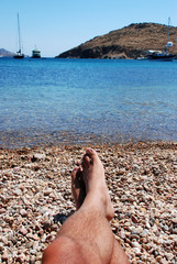 Feet at the beach at Patmos Island in Greece