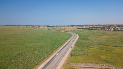 Fototapeta premium Aerial view of white car driving on country road.