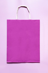 Purple paper bag on a pink background.