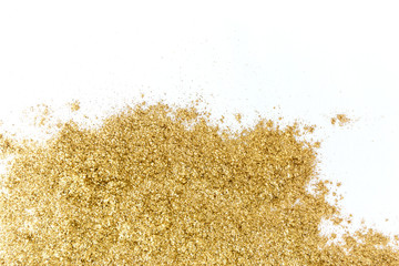 Golden glitter sparkle texture on white background.