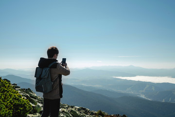 Travel hiker taking photo of majestic mountains range panorama. Carpathian mountains, Ukraine, Europe. Travel background, lifestyle adventure, wide mountains composition