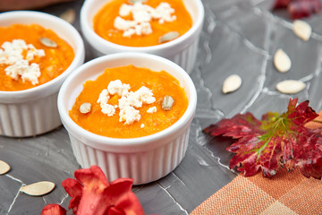 Cream of pumpkin soup or souffle on a gray background.  Thanksgiving Day. Diet vegetarian pupmkin soup puree. Rustic.