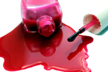 Spilled and open nail polish with a red brush