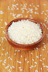 white rice for cooking in a brown wooden plate