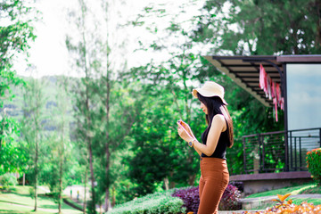 Portrait of asian women relax with green nature, Rest on vacation with nature forest, Smilling and chilling girl, Asian girl stand against green forest with flare sun light