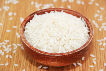 white rice for cooking in a brown wooden plate