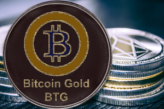 Coin cryptocurrency BTG Bitcoin gold on the background of a stack of coins.