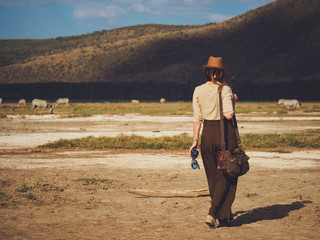 Beautiful woman with binoculars at savanna in Kenya