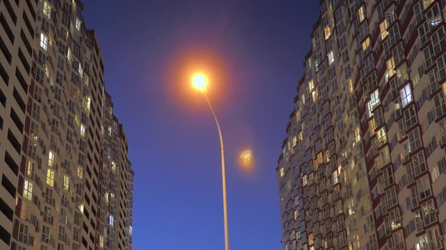 Lights in the windows of tall houses, appartments. Turns on and off the lights in the windows of houses. Lights of the night city. Time lapse. Electricity consumption background