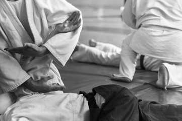 Black and white image of aikido. Hands of fighters. The traditional form of clothing in Aikido....
