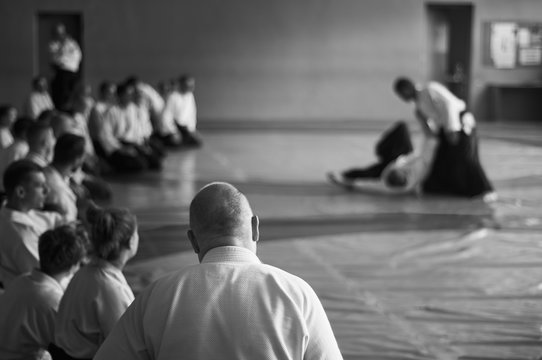 Aikido training. Black and white image. The teacher shows reception.  Traditional form of clothing in Aikido.