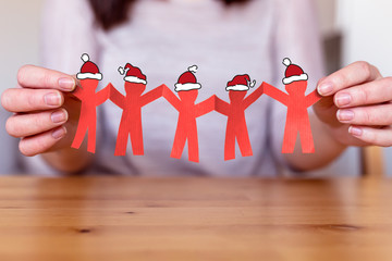 Weihnachtsgruß von uns allem - Team Girlande aus Papier  mit Weihnachtsmannmützen