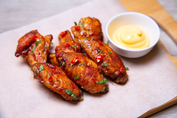 BBQ chicken wings with sauce on paper. Close-up, selective focus.