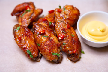BBQ chicken wings with sauce on paper. Close-up, selective focus.