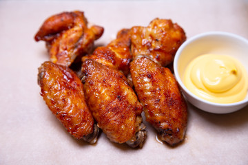 BBQ chicken wings with sauce on paper. Close-up, selective focus.