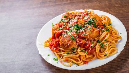 pasta spaghetti with meatballs in tomato sauce on a plate on dark wooden background