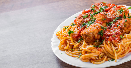 pasta spaghetti with meatballs in tomato sauce on a plate on dark wooden background