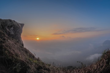 Mountain view of Phu Chi Fa Mountain around with sea of fog with red sun light in the sky background, sunrise at Phu Chi Fa (Phu Chee Fah), Chiang Rai, Thailand.